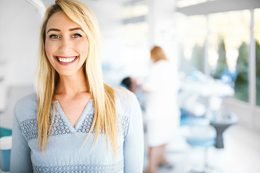 Young female patient smiling and looking at camera after leaving a positive review for Singing River Dentistry in Tuscumbia, AL