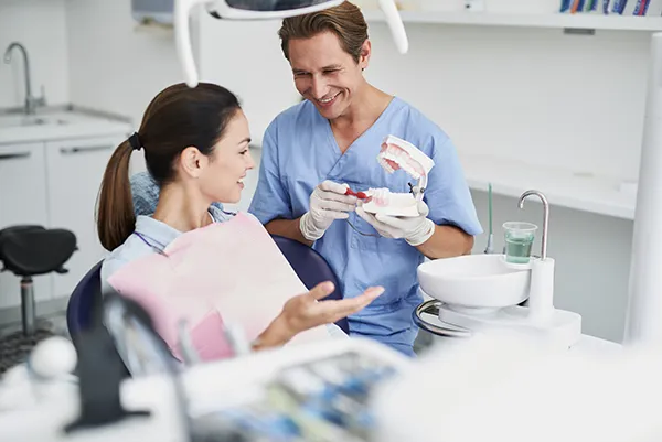 During a consultation appointment, a patient and orthodontist amicably discuss which orthodontic treatment option will best suit the patient's dental situation.